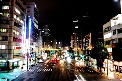 Light trails on road along buildings at night