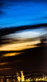 Illuminated cityscape against sky at sunset