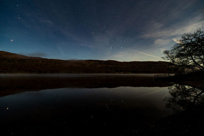 Scenic view of lake against sky at night