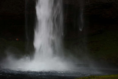 Scenic view of waterfall against sky at night