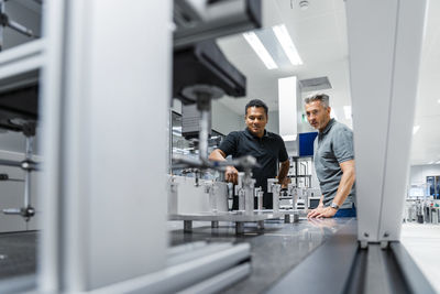 Two men examining machinery at industry