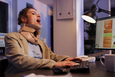 Portrait of woman using mobile phone while sitting on table