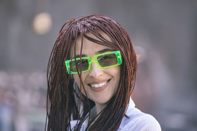 Portrait of young woman wearing sunglasses standing outdoors