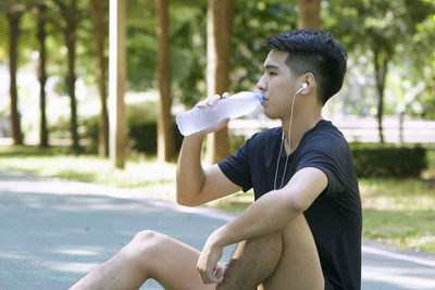 Side view of young woman sitting outdoors