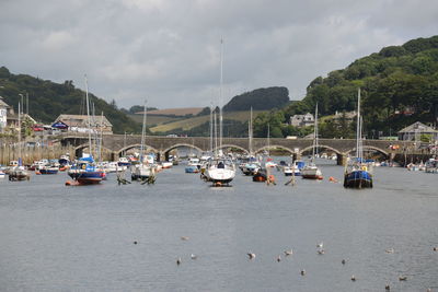 Sailboats moored on river against sky