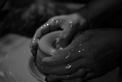 Cropped hand of man working with earthenware