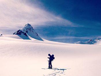 Man skiing on snowcapped mountain against sky