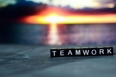 Close-up of text on table at sunset