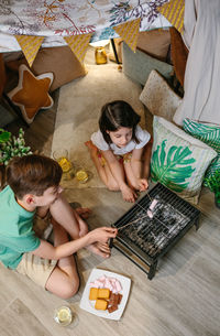 High angle view of kids barbecuing at home