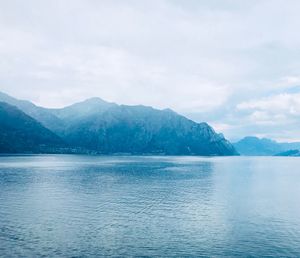 Scenic view of sea by mountains against sky