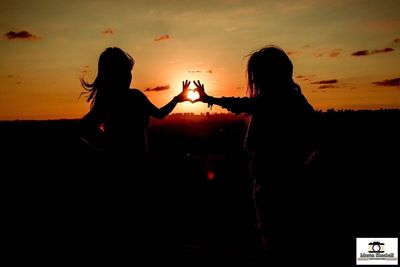 Silhouette couple against sky during sunset