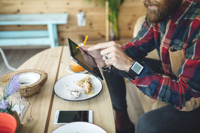 Man sitting in cafe, using digital tablet