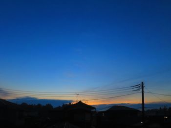 Silhouette buildings against clear sky at sunset