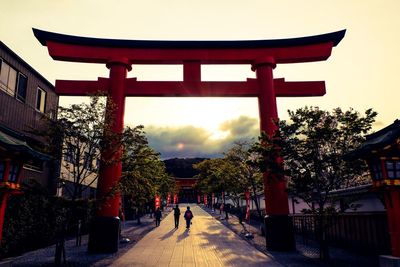 People walking in temple during sunset