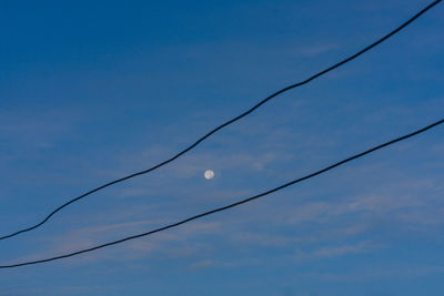 Low angle view of moon against blue sky