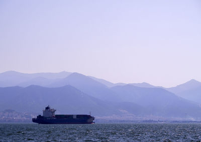 Container ship sailing on sea against clear sky