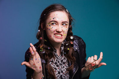 Portrait of young woman against blue background