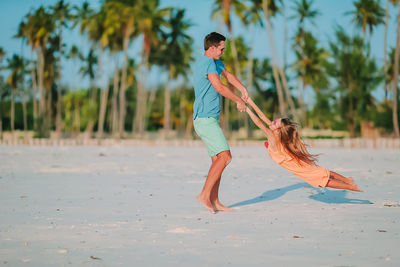 Rear view of people walking on beach