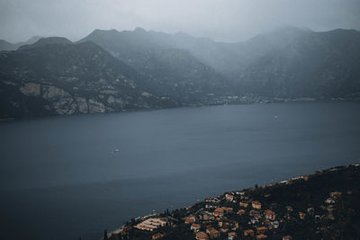 Aerial view of townscape by sea against sky