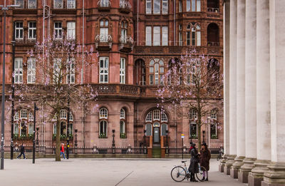 Man riding bicycle on street against building in city