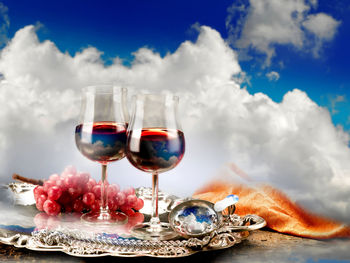 Wine glass on table against sky