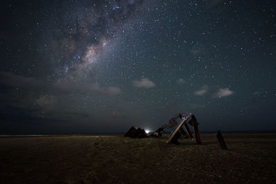 Lifeguard hut on land against sky at night