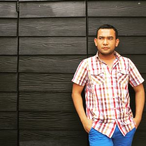 Man standing against wooden door