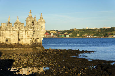 Belem tower by tagus river against sky