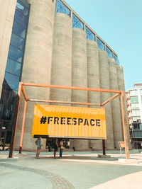 Information sign in city against sky