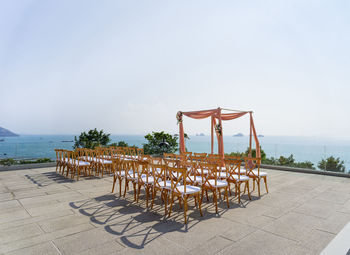 Lifeguard chair by sea against clear sky