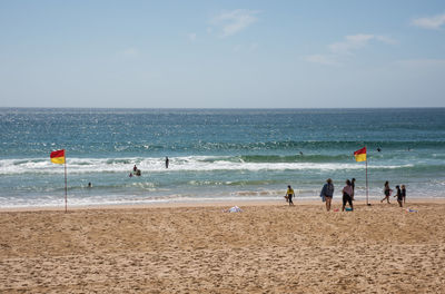 People on beach against sky