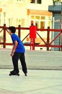 Full length side view of boy inline skating on street