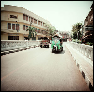 Cars on street amidst buildings in city