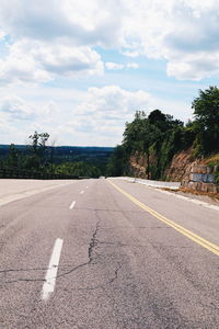 Empty road against cloudy sky