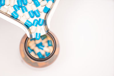 Close-up of pills falling in container