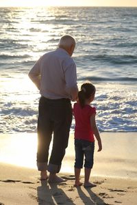 Rear view of couple standing on beach