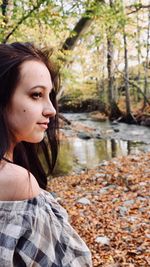 Portrait of smiling young woman against lake