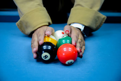 Cropped hand of person playing pool table