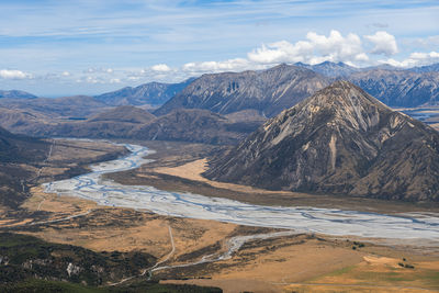 Mountains above a braided river during summer in arthur's pass, new zealand