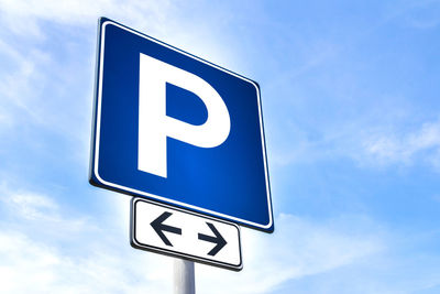 Low angle view of road sign against blue sky