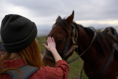 Rear view of women wearing hat against sky