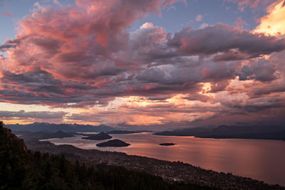 Scenic view of lake against dramatic sky during sunset