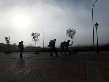 People walking on street against sky