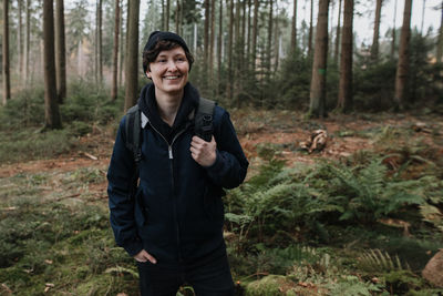 Portrait of smiling young woman in forest