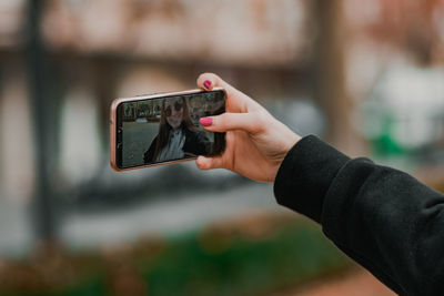 Midsection of person photographing with mobile phone