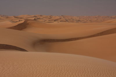 Sand dune in desert against sky