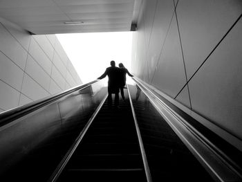 Rear view of man on escalator