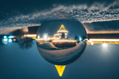 Close-up of illuminated light against cloudy sky