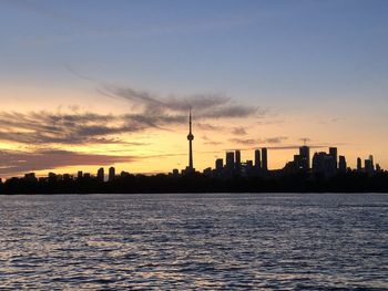 Silhouette of buildings in city during sunset