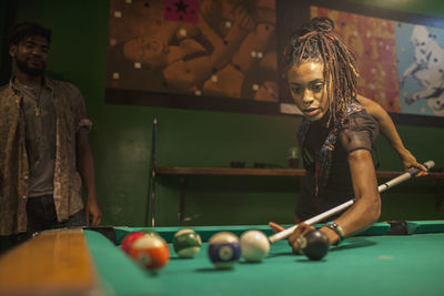 A young woman playing pool.